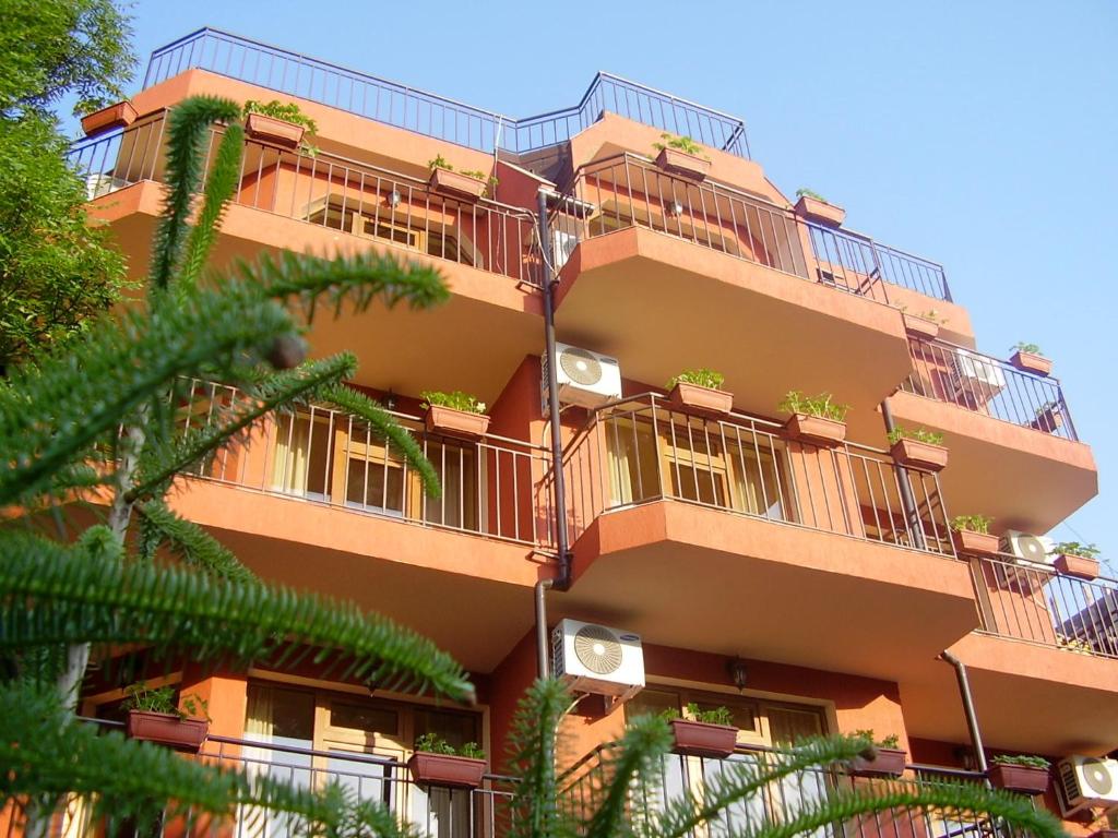 ラブダにあるTerra Guest Houseのバルコニーと木々のあるアパートメントビル
