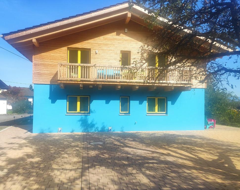 a blue house with a balcony on top of it at Ferienwohnungen Graßmann in Piding