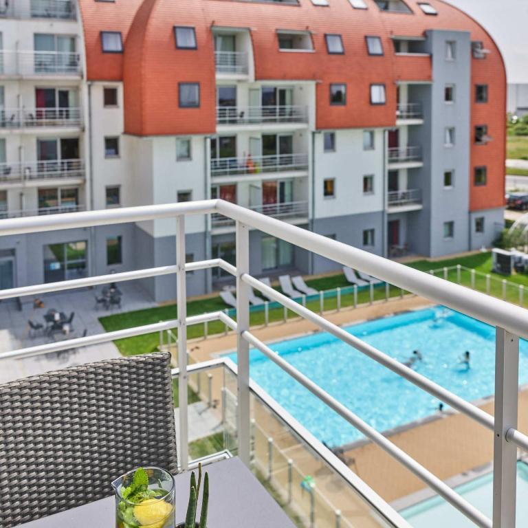 a balcony with a view of a swimming pool at Holiday Suites Zeebrugge in Zeebrugge