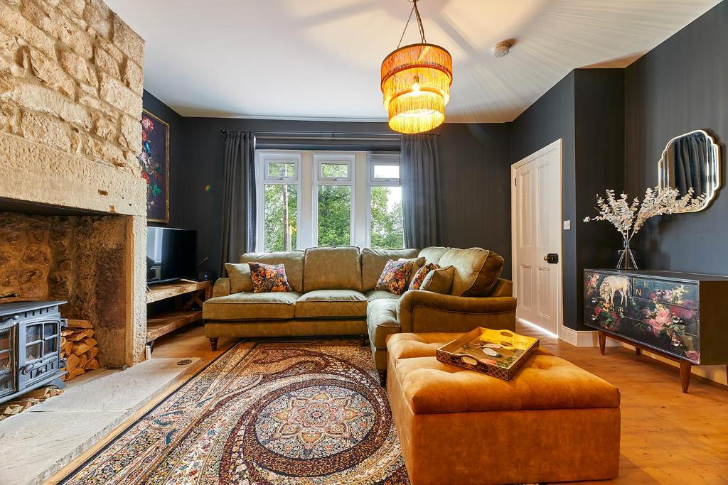 sala de estar con sofá y chimenea en Host & Stay - Percy Cottage, en Otterburn