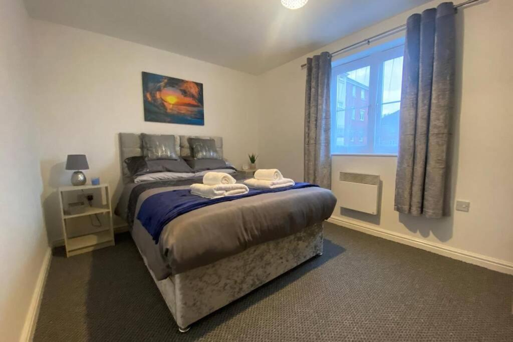 um quarto com uma cama grande e uma janela em The Onyx Suite - 1 Bed apartment w/ free parking em Cardiff