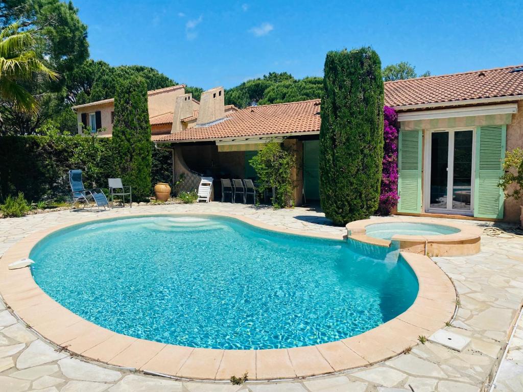 a swimming pool in a yard with a house at villa avec jacuzzi in Sainte-Maxime