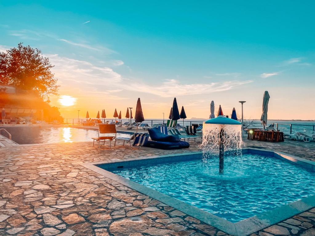 ヴロラにあるAqua Holiday Apartmentsの海の正面に噴水のあるスイミングプール