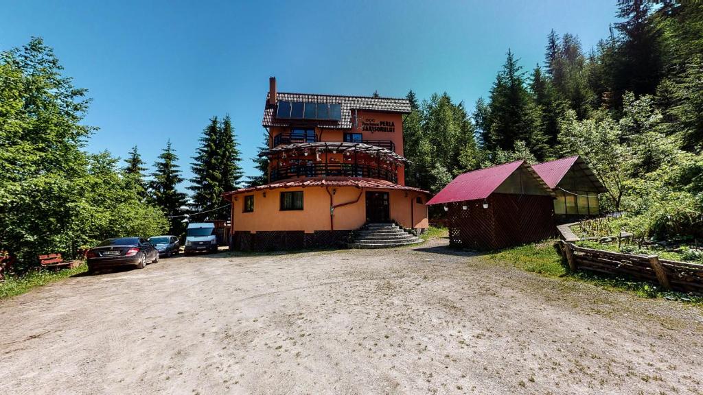 a large house on top of a dirt road at Perla Sarisorului in Sărişor