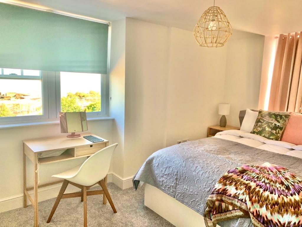 a bedroom with a bed and a desk and a chair at SkyView Eastbourne 24 in Eastbourne
