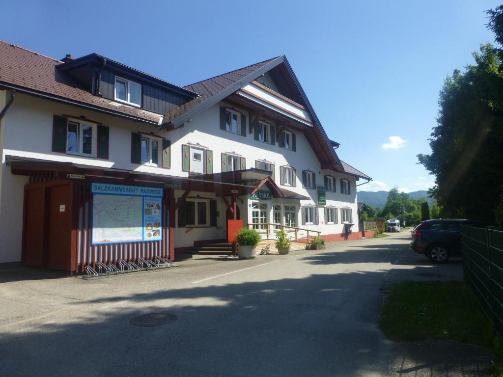 un gran edificio blanco con un cartel delante en ROSSLWIRT-Rast en Strass im Attergau