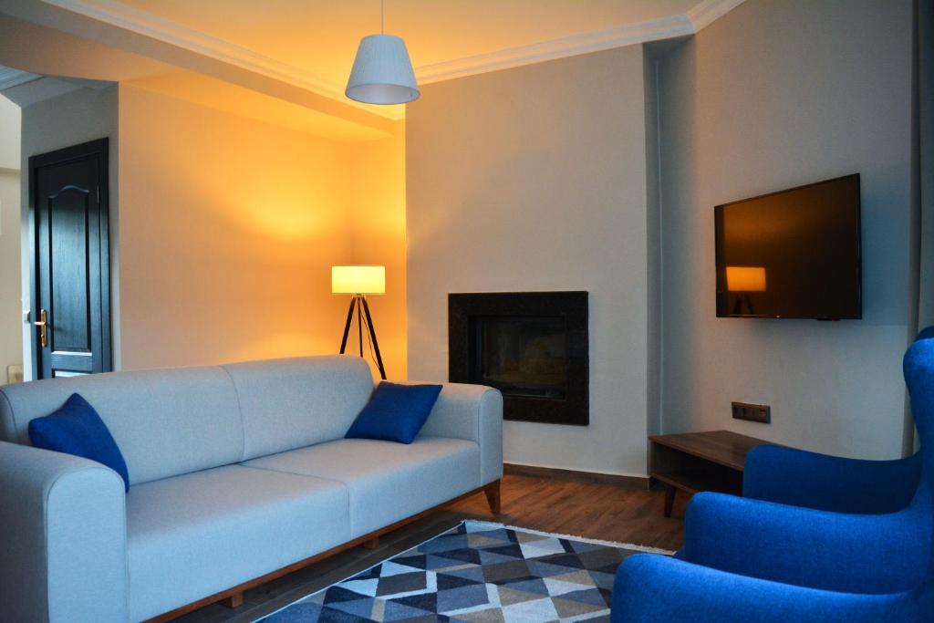 ein Wohnzimmer mit einem Sofa und zwei blauen Stühlen in der Unterkunft Kemer Babel Residence in Kemer