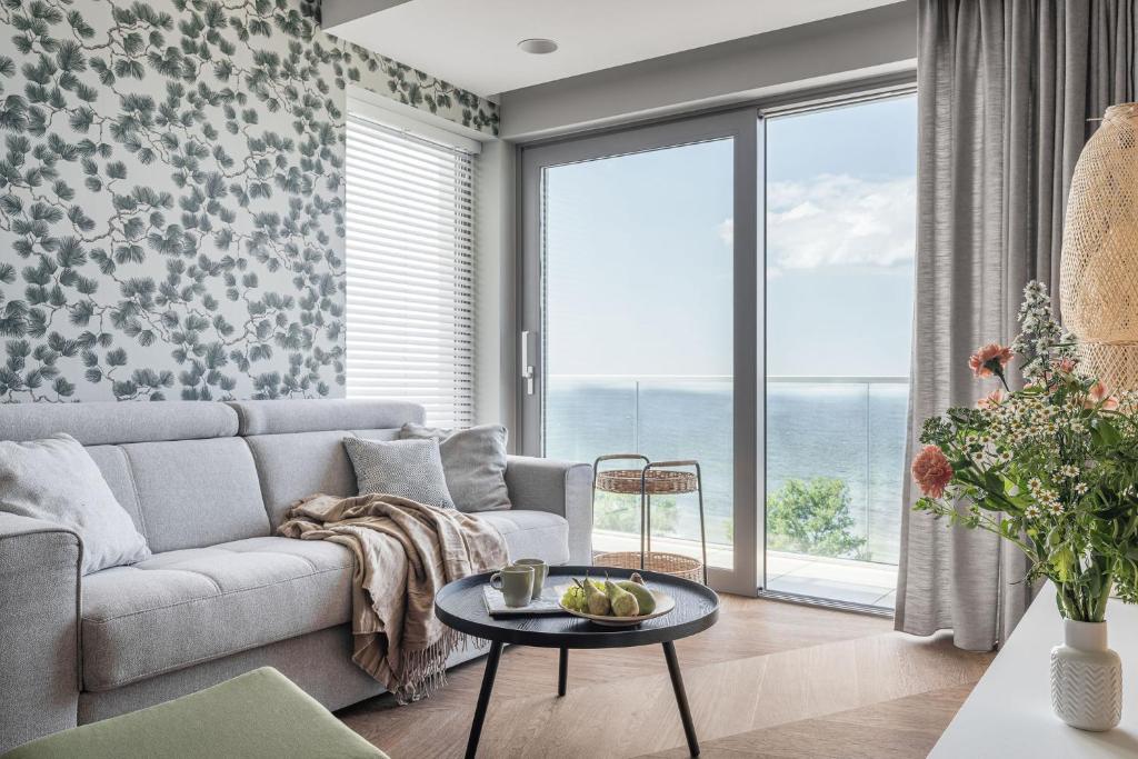 a living room with a couch and a table at Apartamenty Balticus SeaView by Rent like home in Międzyzdroje