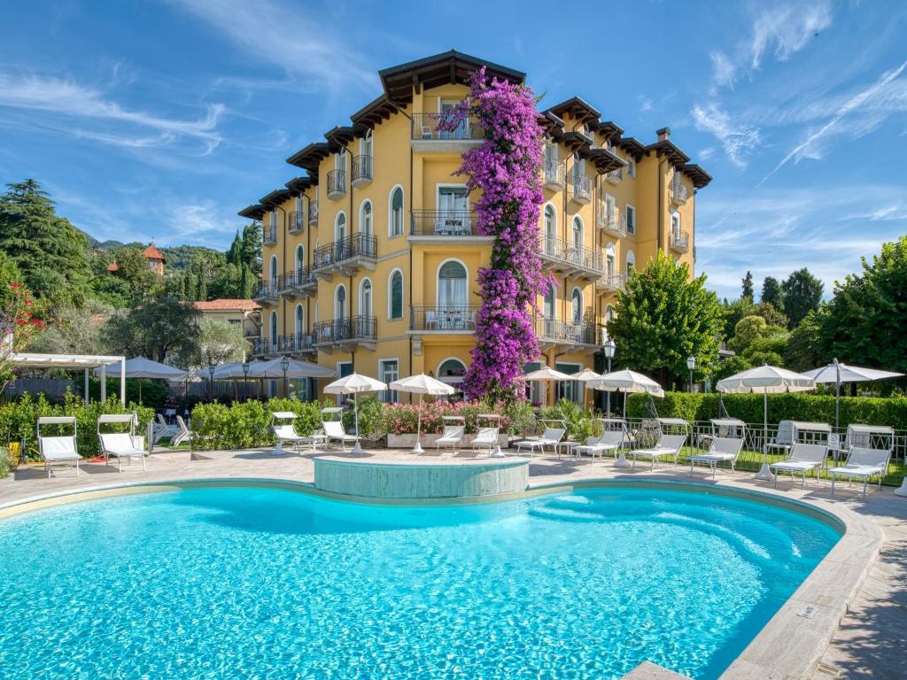 a hotel with a swimming pool in front of a building at Hotel Galeazzi in Gardone Riviera