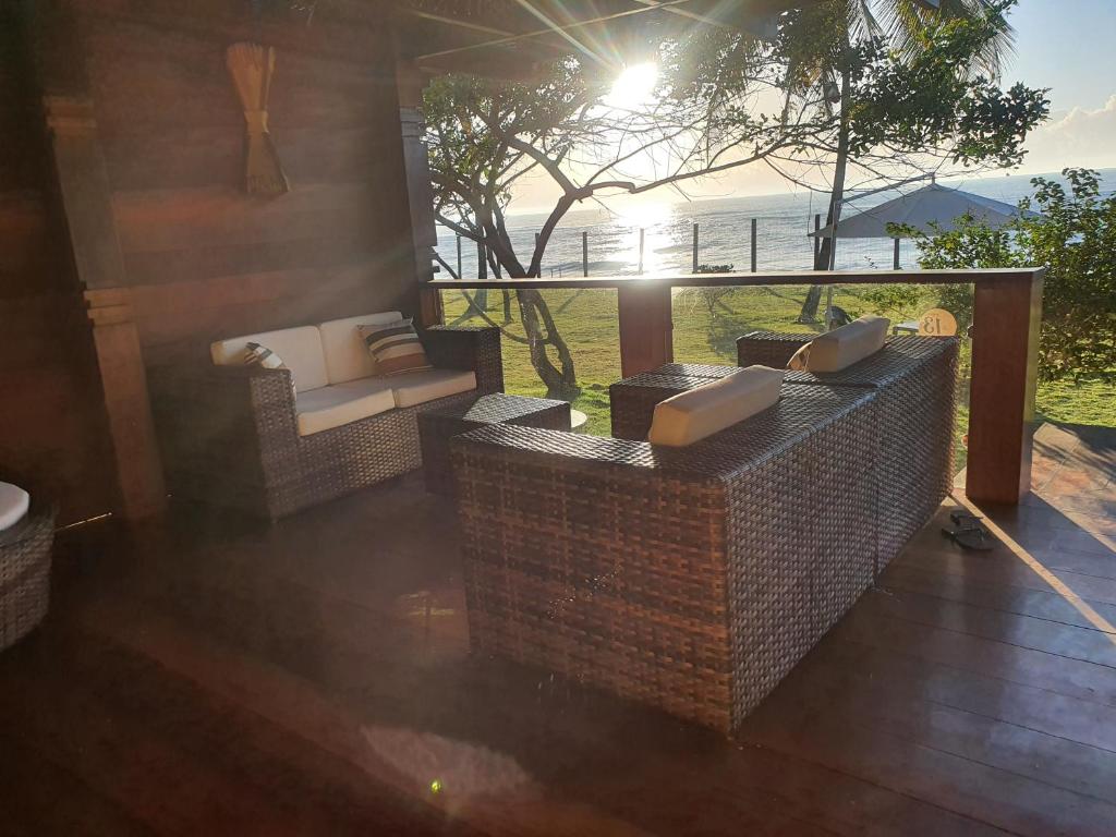 a living room with couches and a view of the ocean at Pé na Areia Praia Pitinga Casa13- Arraial d'Ajuda in Porto Seguro