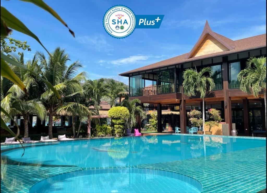 un complexe avec une grande piscine en face d'un bâtiment dans l'établissement Phi Phi Villa Resort-SHA Extra Plus, sur les Îles Phi Phi