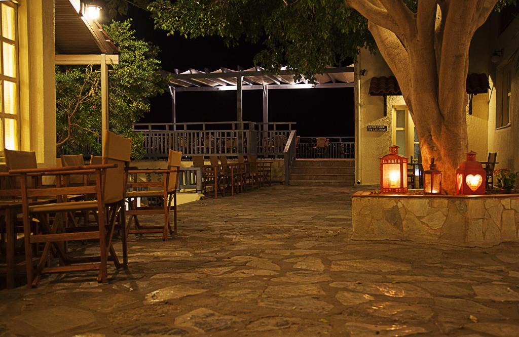 a patio with tables and chairs at night at Elpida Village in Istro