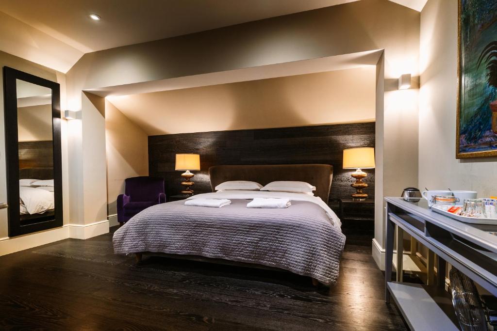 um quarto com uma cama grande com duas toalhas em Chippenham Park Garden Rooms em Chippenham