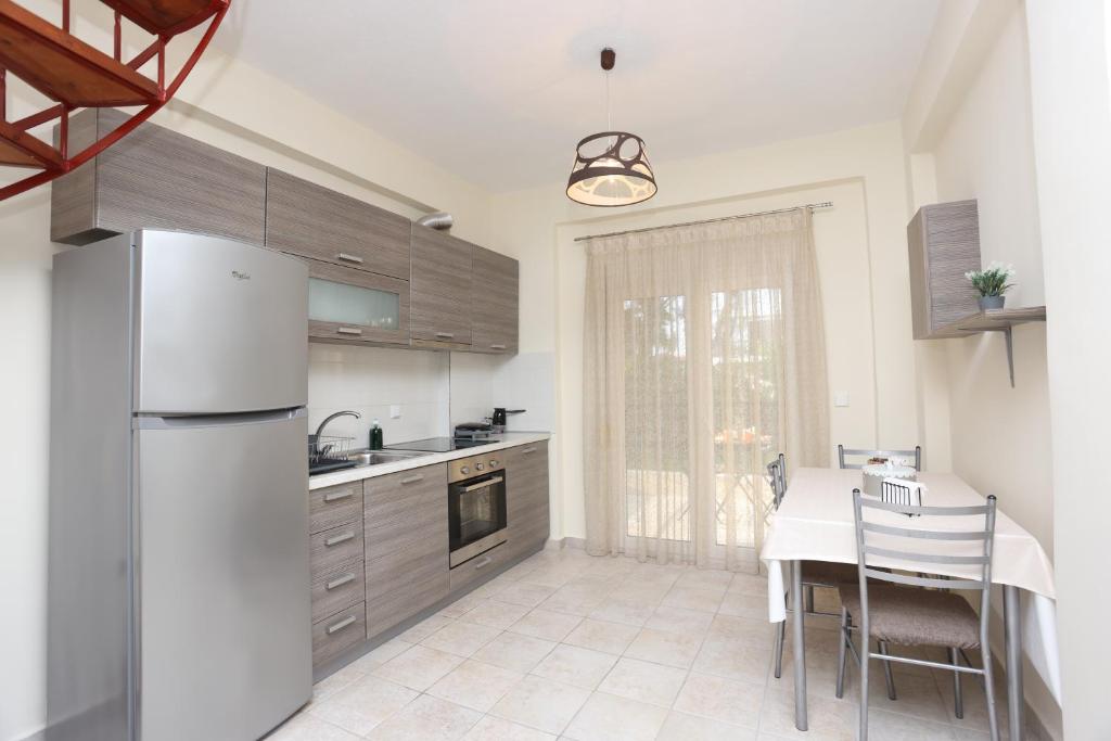una cucina con un frigorifero bianco e un tavolo con sedie di Luxury Villas Polychrono a Polykhrono