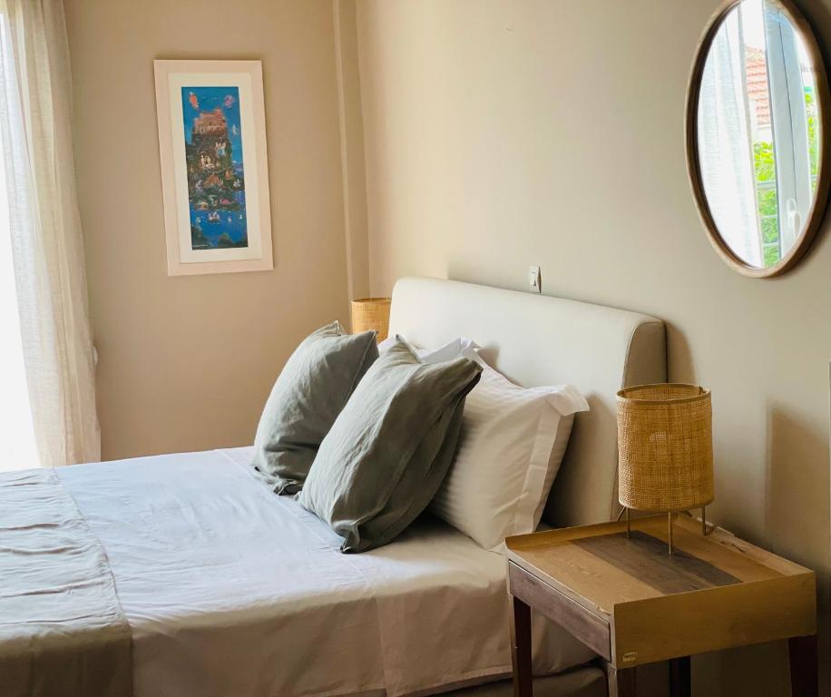 ein Schlafzimmer mit einem Bett mit Kissen und einem Spiegel in der Unterkunft Rex Hotel - Bebeka's in Zakharo