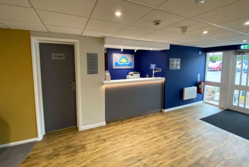 a room with a counter and a blue wall at Days Inn Hotel Sedgemoor in Rooks Bridge