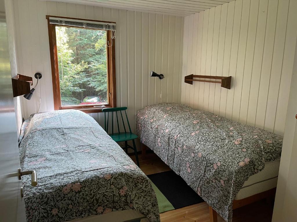 two beds in a room with a window at Fyrvägen 13 'Ydermossa' NEW! in Munka-Ljungby