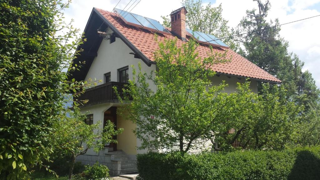 Casa blanca con techo rojo en Apartments Boris, en Bled