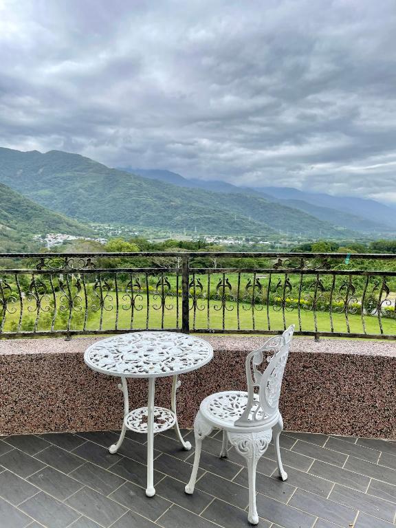 a table and two chairs on a balcony with a view at Lutai B&amp;B in Yung-an-ts&#39;un
