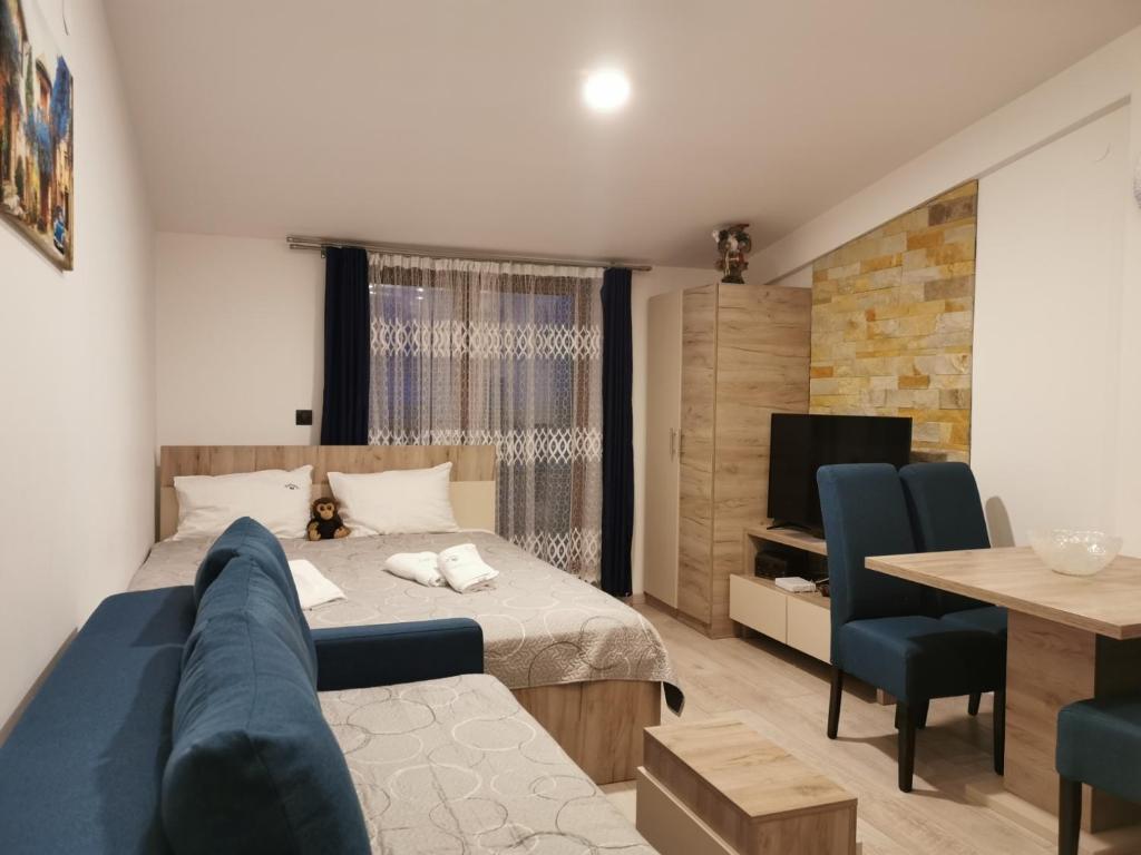 ein Schlafzimmer mit einem Bett, einem Sofa und einem Tisch in der Unterkunft Milmari P85 spa & ski in Kopaonik