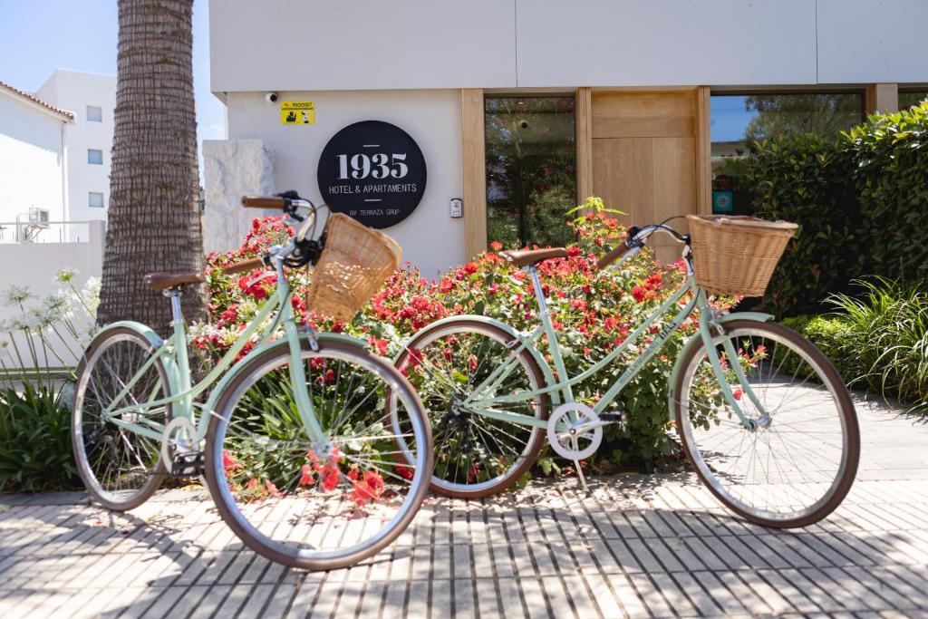 tres bicicletas estacionadas frente a un edificio con flores en 1935 Hotel Boutique by Terraza, en Roses