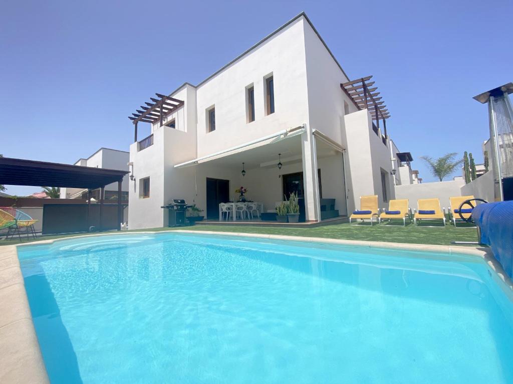 a swimming pool in front of a house at Aquavilla in Costa Teguise