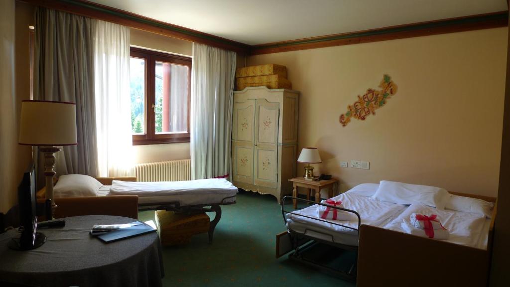 pokój hotelowy z dwoma łóżkami i oknem w obiekcie RTA Hotel Catturani w Madonna di Campiglio