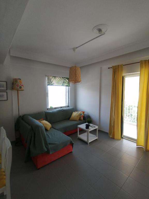 a living room with a couch and a window at Elef Apartment in Paralia Dionysiou
