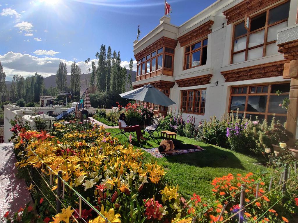 a garden in front of a building with flowers at Namra Villa in Leh