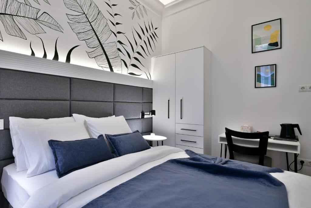 Luxury Galla Apartments in the City Center في سراييفو: غرفة نوم بسرير كبير ومكتب