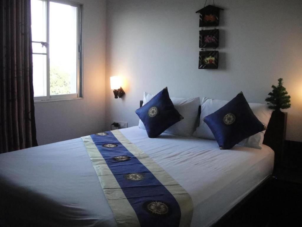 - une chambre avec un grand lit et des oreillers bleus dans l'établissement The CK Residence Pattaya, à Pattaya
