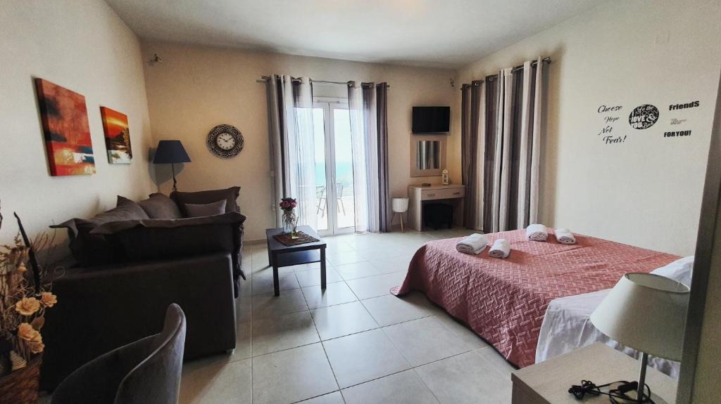 um quarto com uma cama e um sofá num quarto em V&D Paleokastritsa Apartments em Lákones