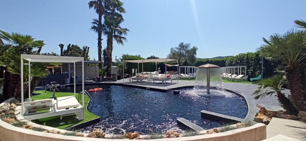 a pool with a fountain in a yard with palm trees at Grand hotel irpinia & Family SPA in Avellino