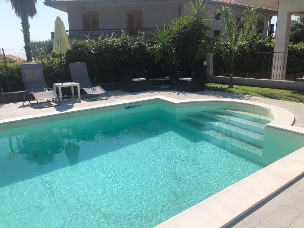 - une piscine d'eau bleue dans la cour dans l'établissement Royal Etna Stars, à Zafferana Etnea