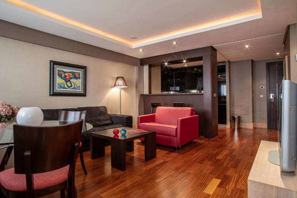 a living room with a couch and a table at Washington Parquesol Suites & Hotel in Valladolid