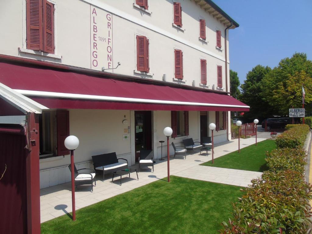 grupa krzeseł siedzących poza budynkiem w obiekcie Albergo Grifone 1891 w mieście Peschiera del Garda