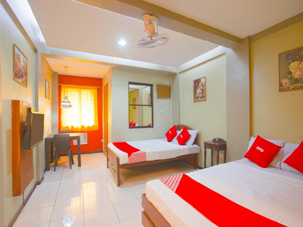 Habitación de hotel con 2 camas y TV en OYO 802 Ka Farah's Inn en Antipolo