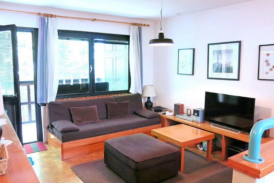 sala de estar con sofá y TV en Apartment Alpe, en Kranjska Gora