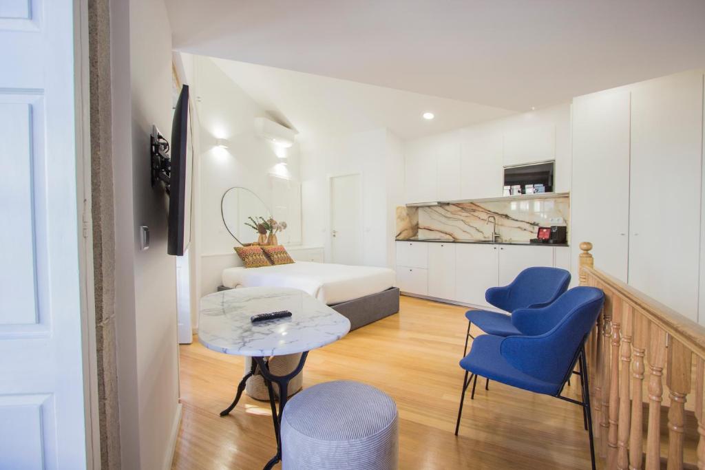 ein kleines Zimmer mit einem Bett, einem Tisch und Stühlen in der Unterkunft Liceiras Apartments By Guestify in Porto