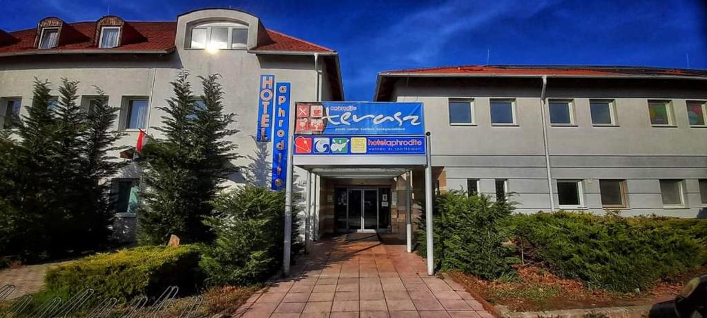 a building with a sign in front of it at Aphrodite Hotel in Göd