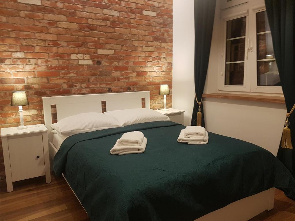 a bedroom with a bed with two towels on it at H&T Apartament Przy Starym Ratuszu in Gdańsk