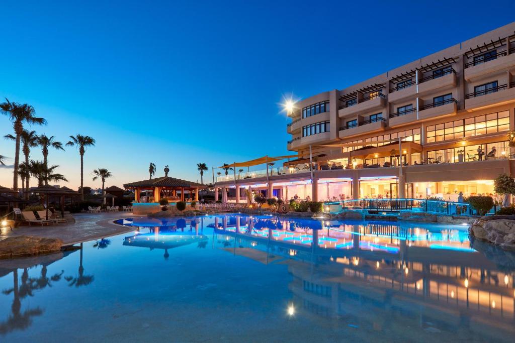 een hotel met een zwembad voor een gebouw bij Atlantica Golden Beach Hotel - Adults Only in Paphos City