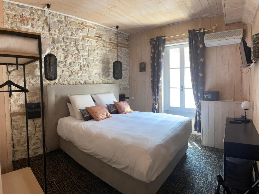 um quarto com uma cama grande e uma parede de pedra em Le Sakura em Morestel