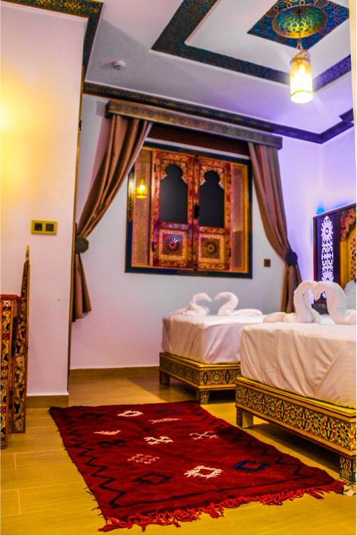 Riad Azemmat في شفشاون: غرفة نوم بسريرين وسجادة حمراء