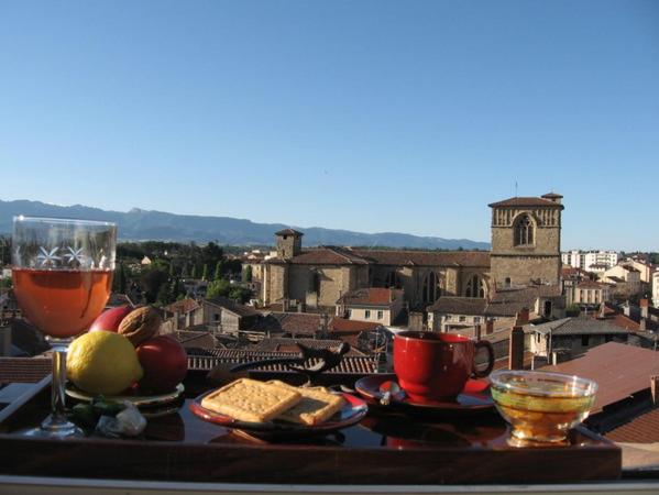een tafel met eten en drinken op de top van een stad bij Sylvie BARON - Composition Française - Chambres d'hôtes in Romans-sur-Isère