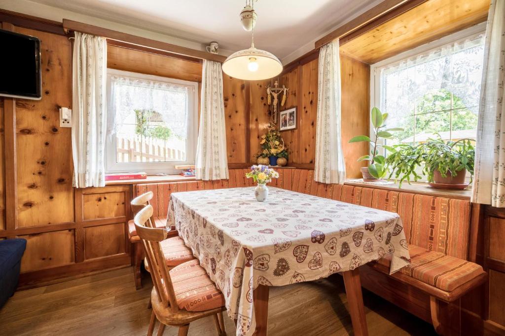 a dining room with a table and two windows at Haus Adler in Maranza