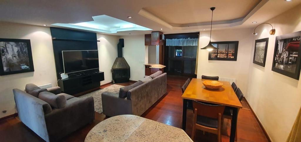 ein Wohnzimmer mit Sofa und Tisch in der Unterkunft Casa no coração de gramado in Gramado