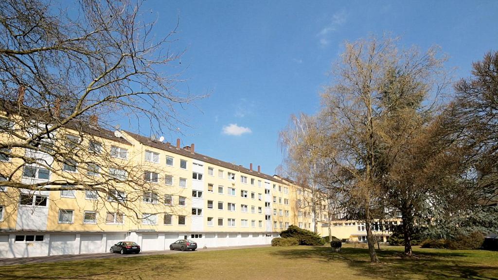 a large white building with trees in front of it at WelcomeCologne Apartments in Cologne