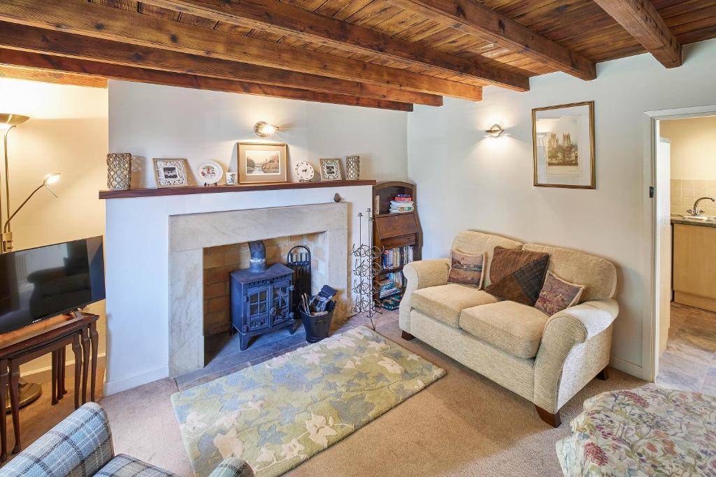 sala de estar con chimenea y sofá en Host & Stay - Grange Cottage en Osmotherley