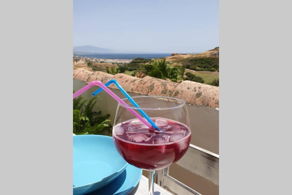een drankje in een glas op een tafel met uitzicht bij Precioso apartamento, todo equipado, con piscinas in Manilva